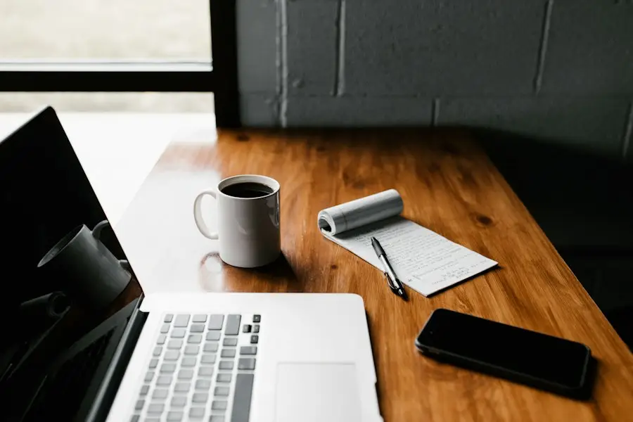 Ordinateur portable, carnet et tasse sur une table en bois