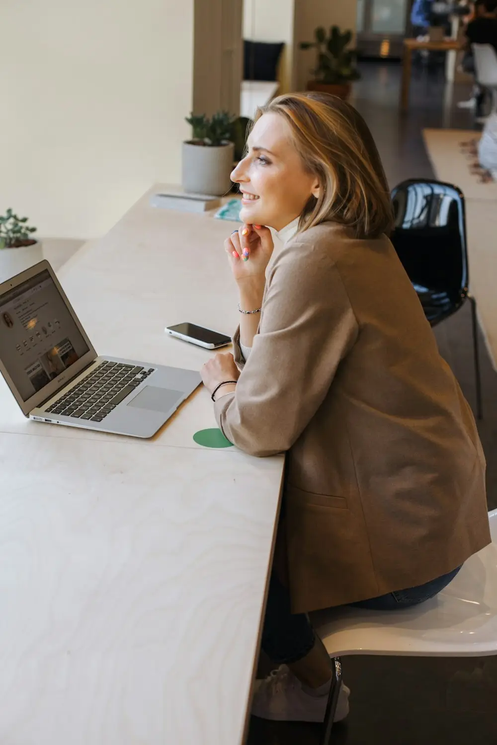 Une professionnelle souriante devant son ordinateur portable
